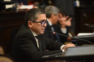 El Senado aprobó con modificaciones una iniciativa que busca frenar el crecimiento del parque de tragamonedas y fortalecer el control estatal. El proyecto vuelve a la Cámara de Diputados para su revisión final. La Cámara de Senadores dio sanción a un proyecto de Ley que prohíbe la ampliación del número de máquinas tragamonedas en salas de juego, tanto públicas como privadas, en todo el ámbito provincial. La iniciativa, impulsada originalmente por el diputado (MC) Omar Sorroche, fue modificada en su paso por el Senado y deberá volver en revisión a la Cámara de Diputados. Según explicó la senadora Natacha Eisenchlas, el proyecto fue desarchivado con la intención de reabrir el debate sobre los límites al crecimiento del parque de tragamonedas en Mendoza, ante una problemática social que afecta a muchas familias: la ludopatía. Durante el tratamiento en el recinto, el senador Walther Marcolini indicó que el texto fue analizado y enriquecido en la comisión de Legislación y Asuntos Constitucionales. En su intervención, remarcó que se trata de una medida preventiva que busca no solo frenar el aumento de máquinas, sino también promover el juego responsable. La autoridad de aplicación será el Instituto Provincial de Juegos y Casinos, que tendrá a su cargo el control del cumplimiento de la norma, incluyendo la fiscalización del parque actual y la posibilidad de aplicar sanciones en caso de incumplimientos. Entre los aspectos centrales del proyecto, se establece que las salas deberán implementar programas de concientización sobre los riesgos del juego compulsivo, brindar asistencia a personas con conductas problemáticas y capacitar al personal para su detección. Durante el debate, el senador Dugar Chappel (Partido Verde) manifestó su desacuerdo con la iniciativa. En tanto, el justicialista Félix González anunció que su bloque acompañaría el proyecto, pero llamó a profundizar el trabajo para combatir el juego online y clandestino. Con esta medida, Mendoza busca dar un paso firme en la regulación del juego y en la protección de la salud pública, estableciendo límites claros y promoviendo espacios más seguros para la comunidad.